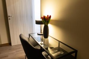 a glass table with a vase with flowers on it at Maison dei Mori in Messina +1 photo