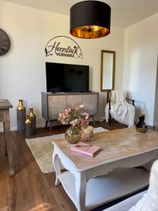 a living room with a table and a tv at Herzstück in Schwanebeck