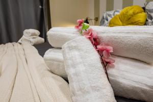 a pile of towels with pink flowers on them at Maison dei Mori in Messina
