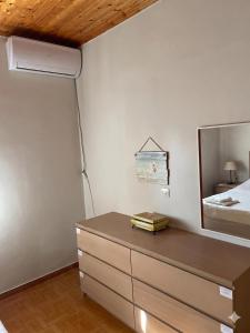 a bedroom with a bed and a dresser with a mirror at Thanasis house in Dimitsana