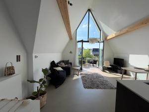 a living room with white walls and a large window at Waterfront in Alkmaar