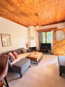 a living room with a couch and a tv at Christina's Sea View House in Yénion