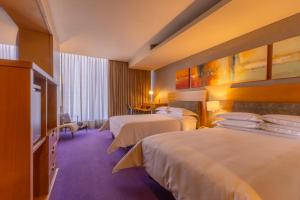 a hotel room with two beds and a television at Barceló México Santa Fe in Mexico City