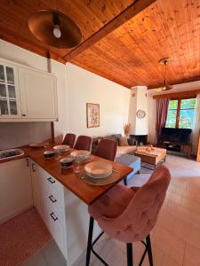 a kitchen and living room with a wooden ceiling at Christina's Sea View House in Yénion