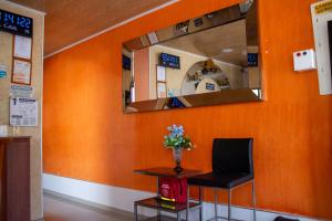 a waiting room with a chair and a mirror at Hotel Perla Azul Girardot in Girardot