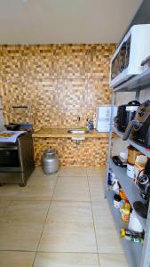 a kitchen with a counter with a stove and a shelf at Home Hostel Maceió in Maceió