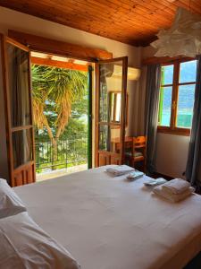 a bedroom with a large bed with a large window at Christina's Sea View House in Yénion