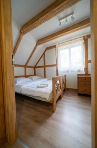 a bedroom with a bed and a window at Domek Na Gwizdówce nr52 in Załakowo