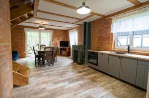 a kitchen and dining room with a table and chairs at Domek Na Gwizdówce nr52 in Załakowo