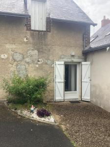 a house with white doors on the side of it at Chez titi et carole in Dissay-sous-Courcillon