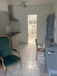 a kitchen with two chairs and a table in a room at Chez titi et carole in Dissay-sous-Courcillon +4 photos