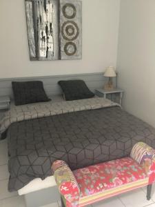 a bedroom with a bed and a bench in it at Chez titi et carole in Dissay-sous-Courcillon