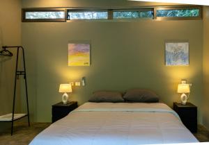 a bedroom with a large bed with two lamps at Elegant and Stylish - Riverside Tiny House Apartment in El Valle
