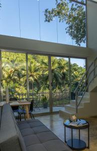 a living room with a couch and a table and palm trees at Elegant and Stylish - Riverside Tiny House Apartment in El Valle