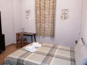 a bedroom with a bed and a table and a window at Courtyard Cottage in Athens