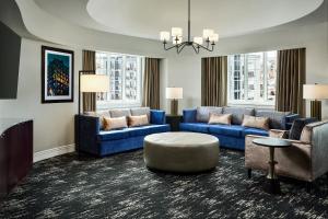 a large living room with blue couches and chairs at Hotel Alex Johnson Rapid City, Curio Collection by Hilton in Rapid City