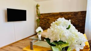 a living room with a table with white flowers at CK Apartment in Oberhofen am Irrsee