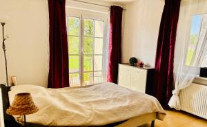 a bedroom with a bed and a large window at CK Apartment in Oberhofen am Irrsee