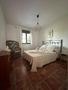 a bedroom with a bed and a chair and a window at El Refugio in Fondón