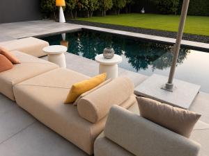 a couch and two chairs in front of a pool at B26 Apartments - Unterwegs zu Hause in Willich