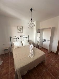 a teddy bear sitting on a bed in a bedroom at El Refugio in Fondón