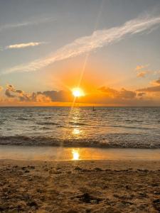 a sunset on the beach with the sun setting at Tamu House Paje in Paje