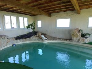 a large swimming pool in a house with rocks at Domaine de buffevent in Cintegabelle
