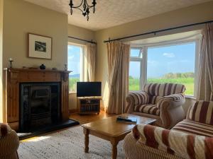ein Wohnzimmer mit Kamin und Fernseher in der Unterkunft Three Sisters in Dingle