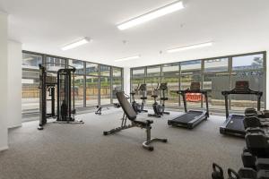 a gym with several treadmills and elliptical machines at Oceanside Resort & Twin Towers in Mount Maunganui