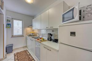 a kitchen with white cabinets and a refrigerator at Pool House Lilly - Happy Rentals in Višnjan