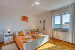 a bedroom with a large bed and a large window at Pool House Lilly - Happy Rentals in Višnjan
