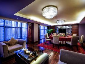 a living room with a table and a dining room at Grand Mercure Xiamen Downtown-Free Welcome Fruit & Metro Station in Xiamen