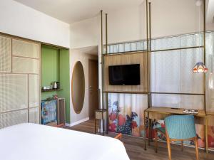 a bedroom with a bed and a desk and a tv at Mercure Rio Boutique Hotel Copacabana in Rio de Janeiro