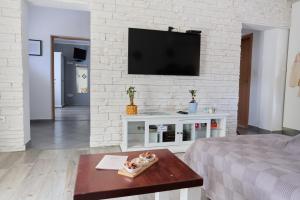 a living room with a tv on a white brick wall at House Mellifera in Razvođe