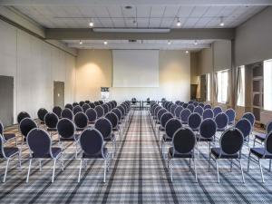 an empty room with rows of chairs and a screen at Mercure Orléans Portes de Sologne in Ardon