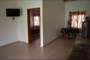 ein Wohnzimmer mit Fernseher und Tisch in der Unterkunft Hotel gallego in Campeche
