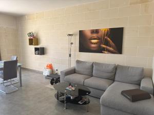 a living room with a couch and a wall at Sea Views Penthouse Apartment in Xagħra