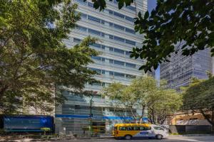 a yellow bus parked in front of a tall building at City Express by Marriott Ciudad de México EBC Reforma in Mexico City