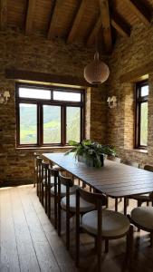 a dining room with a wooden table and chairs at Casa de piedra en el valle a 20 minutos de Ribadeo y Playa de las Catedrales in Salcido
