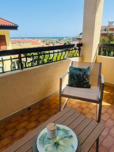 a balcony with a chair and a table with a plate on it at Villa Domini in Soverato Marina