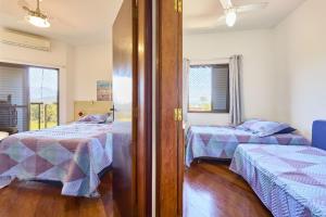 a bedroom with two beds and a window at CHARMOSO seu apto a apenas 300 mts da rua mais turistica de ubatuba in Ubatuba