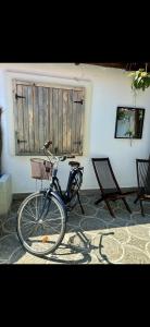 a bike parked in front of a building with two chairs at Nar Suites Alacati in Çeşme