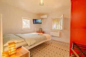 a bedroom with a bed and a tv on the wall at Nar Suites Alacati in Çeşme