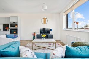 a living room with a blue couch and a table at Modern 2 Bedroom Flat with FREE Parking, Close to Heathrow and Thorpe Park in Staines