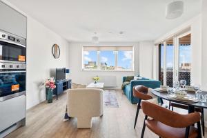a kitchen and living room with a table and chairs at Modern 2 Bedroom Flat with FREE Parking, Close to Heathrow and Thorpe Park in Staines