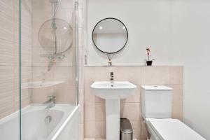 a bathroom with a sink toilet and a mirror at Modern 2 Bedroom Flat with FREE Parking, Close to Heathrow and Thorpe Park in Staines +16 photos