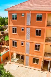 an orange apartment building with white windows at Mol Mot Hotel in Gulu