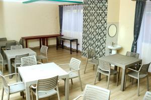 a dining room with tables and white chairs at Mol Mot Hotel in Gulu +11 photos
