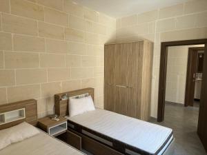 a room with two beds and a cabinet in it at Sea Views Penthouse Apartment in Xagħra +5 photos