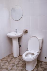 a bathroom with a white toilet and a sink at Mol Mot Hotel in Gulu